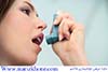 Woman using inhaler to treat asthma attack